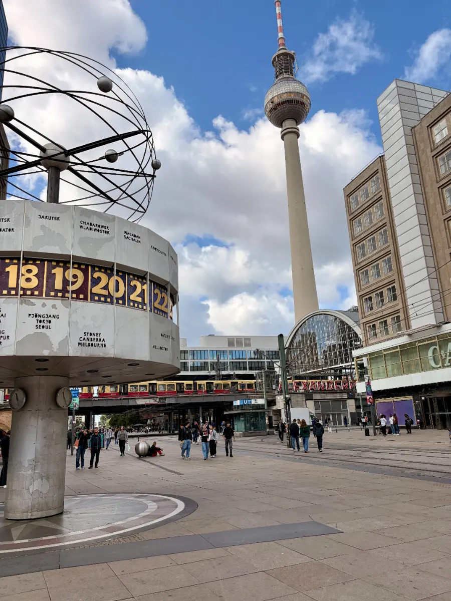 Alexanderplatz in Berlin mit Weltzeituhr, Fernsehturm, Bahnhof und Passanten auf dem Platz