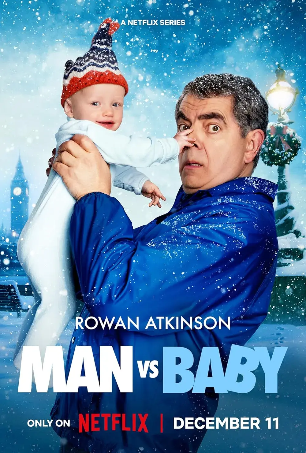 Ein Filmplakat zur Netflix-Serie „Man vs Baby“: Rowan Atkinson blickt schockiert, während ein lächelndes Baby ihm einen Finger in die Nase steckt. Hintergrund ist ein verschneites London mit dem Big Ben.