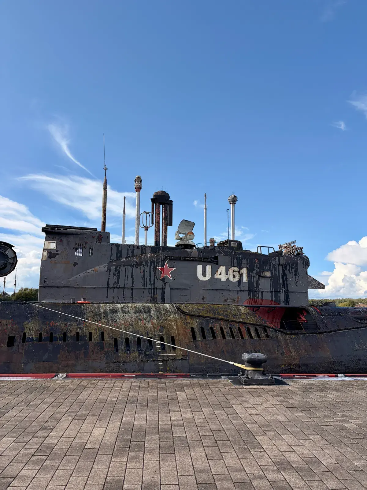 Graues U-Boot U461 als Museumsschiff am Kai unter blauem Himmel