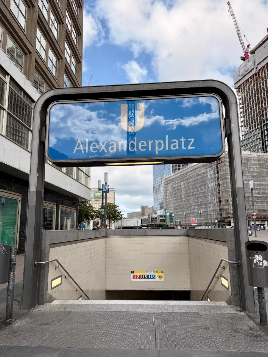 U-Bahn-Eingang am Alexanderplatz in Berlin mit blauem U-Schild zwischen Hochhäusern und Baustelle