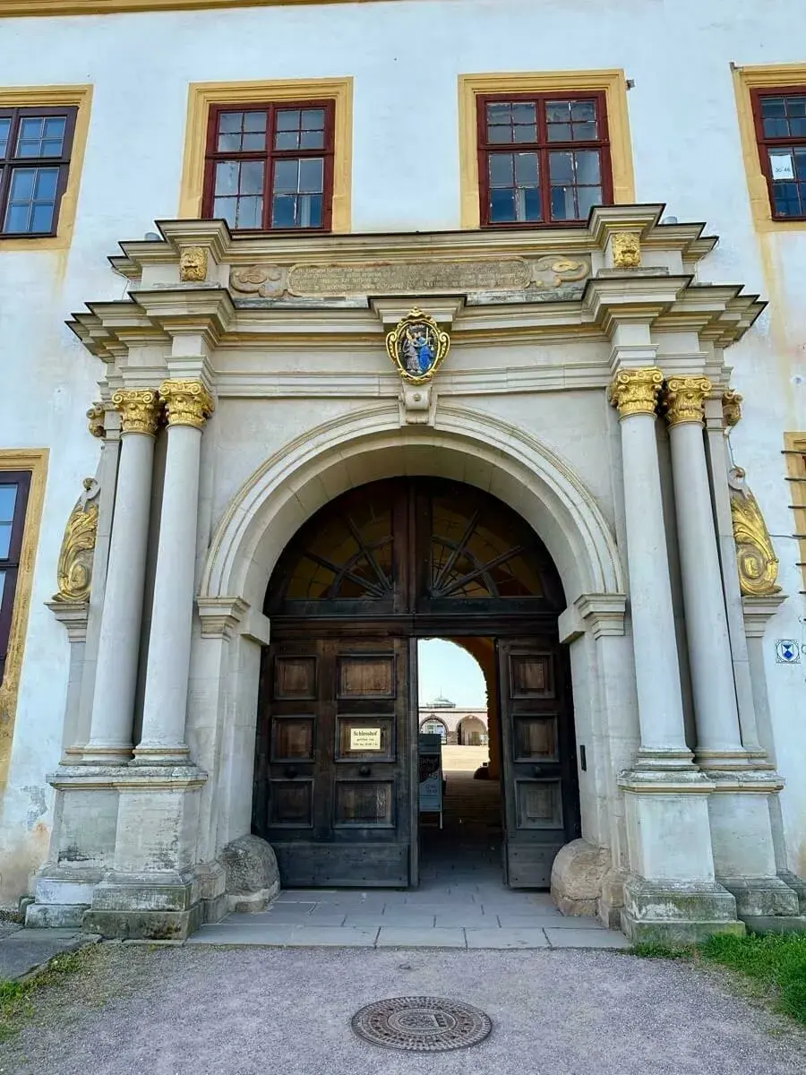 Das aufwendig verzierte steinerne Eingangsportal mit einer großen Holztür vom Schloss Friedenstein.