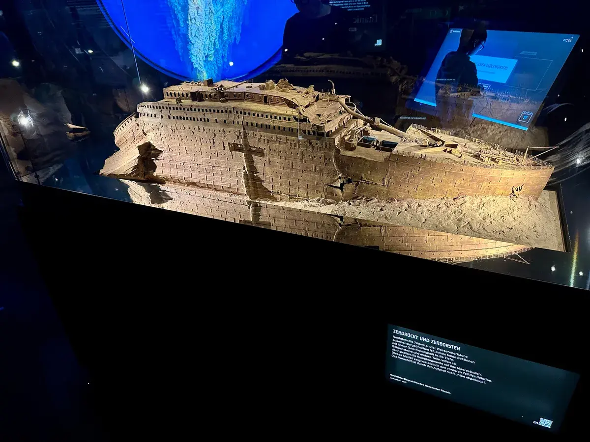 Ein Modell des beschädigten Schiffsrumpfs der Titanic, ausgestellt in einem beleuchteten Vitrinenschrank, ist zu sehen.